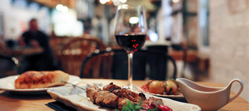 Fotografía de restaurante con copa de vino y comida